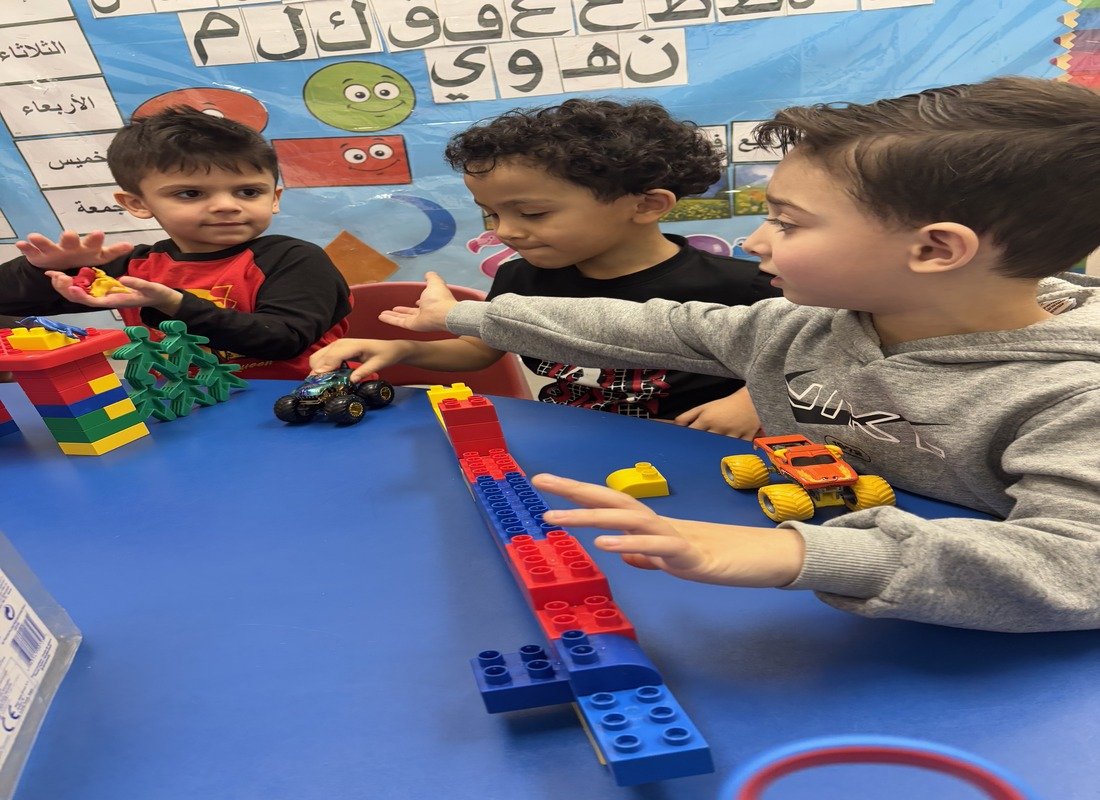 Children playing with colorful building blocks and toy cars in Arabic preschool classroom